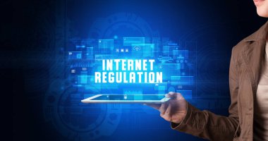 Tablet üzerinde çalışan genç iş adamı dijital işareti gösteriyor: INTERNET Düzenleme