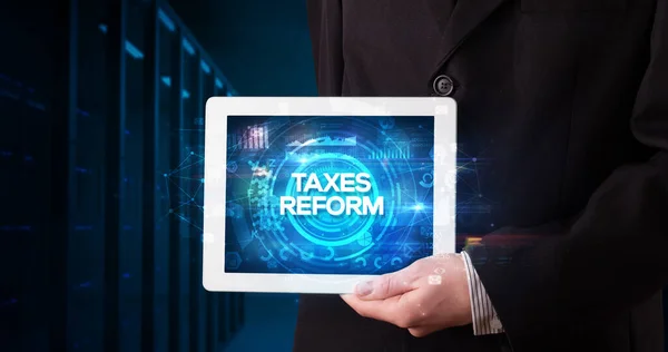 从事平板电脑工作的年轻商人并展示了题词 Taxes Reform 商业概念 — 图库照片