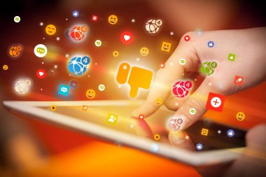 Renkli nefret simgeleri içeren tablet kullanan bir elin yakın çekimi, sosyal ağ konsepti