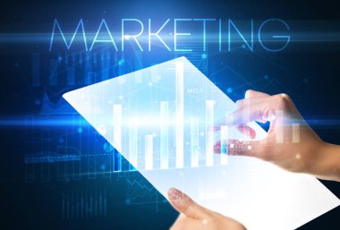 Üzerinde MARKETING yazıtları olan el ele tutuşan fütürist tablet, modern iş kavramı