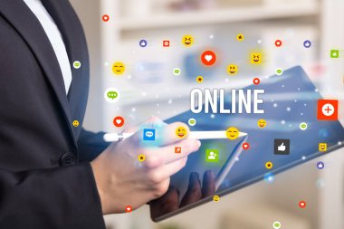 Sosyal medya simgeleri ve ONLINE yazıtlarıyla multimedya oynayan iş adamını kapat