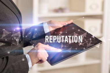 REPUTATION yazıtları ve modern iş teknolojisi kavramı olan tablet kullanarak elleri kapat