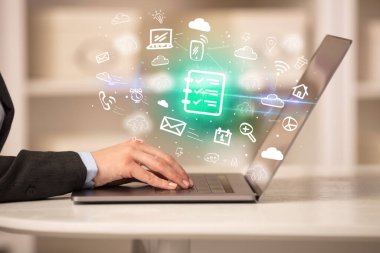 Dizüstü bilgisayarda çalışan iş adamı, içinden liste simgeleri çıkıyor, iş konsepti büyüyor