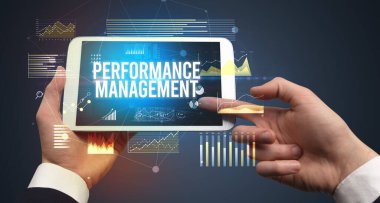 Performans Yönetimi yazılı tableti, modern iş konsepti olan ellerin yakın çekimi