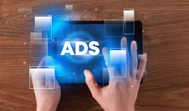 ADS kısaltması, modern teknoloji konsepti olan bir tabletin el ele tutuşması.