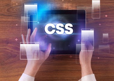 CSS kısaltmalı, modern teknoloji kavramlı el ele tutuşma tabletinin yakın çekimi