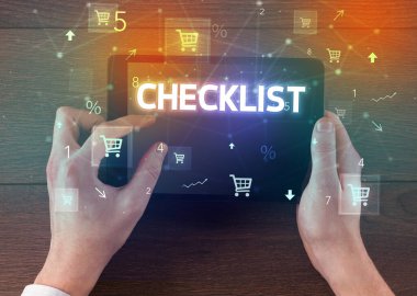 CHECKLIST yazıtlı, çevrimiçi alışveriş konsepti olan bir el tutma tabletinin yakın çekimi