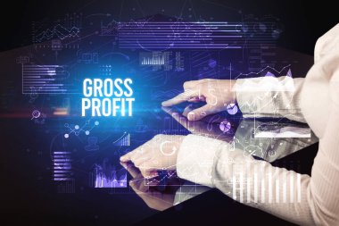 İşadamı GROSS PROFIT yazıtları ve siber iş konseptiyle büyük ekrana dokunuyor