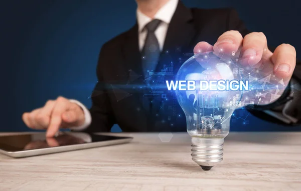 手握灯泡的商人 带有Web设计题字 创新技术概念 — 图库照片