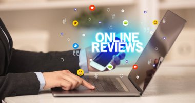ONLINE REVIEWS yazıtlı, Sosyal medya konseptli dizüstü bilgisayar kullanan serbest çalışan kadın