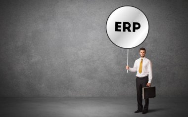 Genç iş adamı ERP kısaltmalı trafik levhası taşıyor, teknoloji çözüm kavramı