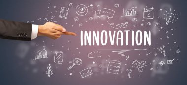 Kesilmiş ellerin yakın çekimi INNOVATION yazıtlarına işaret ediyor, modern iş çözümleri kavramı