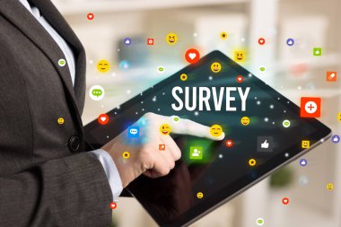 Sosyal medya simgeleri ve SURVEY yazıtlarıyla multimedya oynayan işadamını kapat
