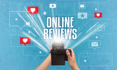 ONLINE REVIEWS yazıtları, sosyal medya kavramı ile fotoğraf çeken bir elin yakın çekimi