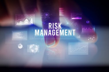 Tablete çizelgeler ve RISK MANAGEMENT yazıtları ile dokunmak, iş konsepti