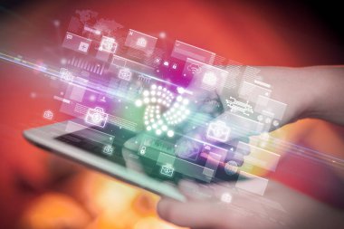 Tablet kullanan bir elin yakın plan resmi, tabletten çıkan iota simgeleri, dijital para birimi konsepti