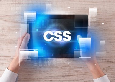 CSS kısaltmalı, modern teknoloji kavramlı el ele tutuşma tabletinin yakın çekimi