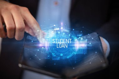 Öğrenci Kredisi ve eğitim konsepti içeren katlanabilir bir akıllı telefon tutan genç adam.