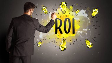 İş adamı ROI kısaltması ile renkli ampul çiziyor, yeni teknoloji fikri