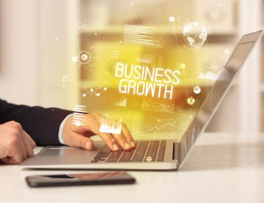 BÜYÜK GROWTH yazıtları ve modern iş konseptiyle birlikte dizüstü bilgisayarda çalışan bir iş adamının yan görüntüsü