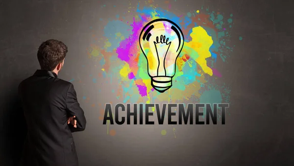 商人画五彩斑斓的灯泡 墙上刻有Achievement字样 新的商业理念 — 图库照片