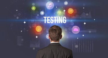TESTING yazıtları ve modern teknoloji kavramına sahip bir iş adamının arka görünüşü