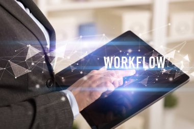 WorKFLOW yazıtları ve modern iş teknolojisi kavramı olan tablet kullanarak elleri kapat