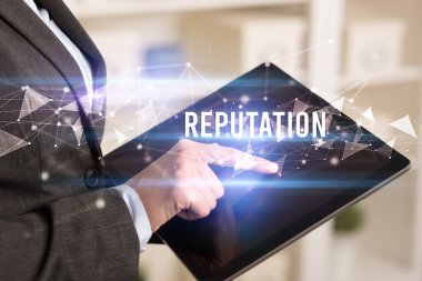 REPUTATION yazıtları ve modern iş teknolojisi kavramı olan tablet kullanarak elleri kapat