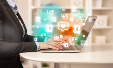 Laptop 'ta kalp ikonları ve sosyal medya konseptiyle sörf yapan genç kişi