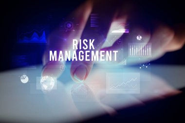 Tablete çizelgeler ve RISK MANAGEMENT yazıtları ile dokunmak, iş konsepti