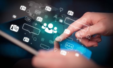 Toplum simgeleri içeren tablet kullanan bir elin yakın çekimi, sosyal medya kavramı