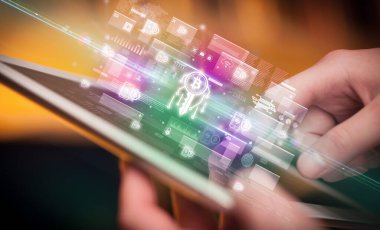 Tablet kullanan bir elin yakın plan görüntüsü, içinden çıkan blok zinciri simgeleri, dijital para birimi kavramı