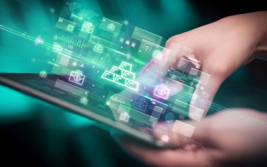 Altın külçeli tablet kullanan bir elin yakın plan fotoğrafı, dijital para birimi konsepti
