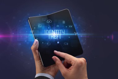 İş adamı elinde kimlik hırsızlığı, siber güvenlik kavramı içeren katlanabilir bir akıllı telefon tutuyor.