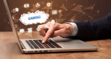 Bilgisayarda oyun yazıtları ve modern teknoloji konseptiyle çalışan bir iş adamı.