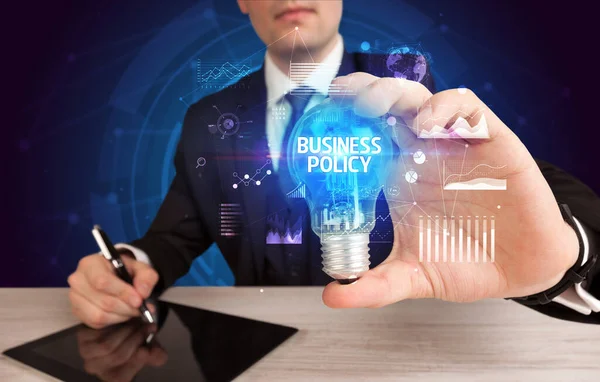 電球をビジネスポリシーの碑文で保持するビジネスマン ビジネスアイデアコンセプト — ストック写真