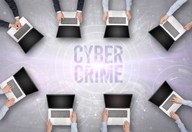 CYBER CRIME insciption, web güvenlik kavramı olan bir dizüstü bilgisayarın önünde bir grup insan