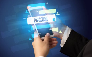 Dişi el, akıllı telefonda CUSTOMER Experience yazısıyla, sosyal ağ konseptiyle yazı yazıyor.