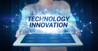 Tablet üzerinde çalışan genç iş adamı ve yazıyı gösteriyor: TEKNOLOJİ HİZMETLİK