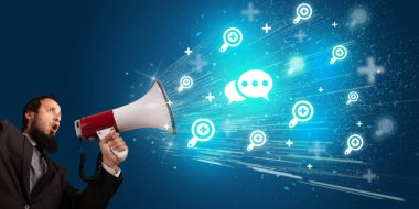 Hoparlörde mesaj ikonu ve sosyal ağ konseptiyle bağıran genç kişi