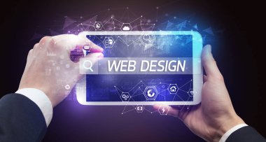 Web 'de arama yapan bir tabletin yakın plan görüntüsü DESIGN yazıtları, yüksek teknoloji bilgisayar kavramı