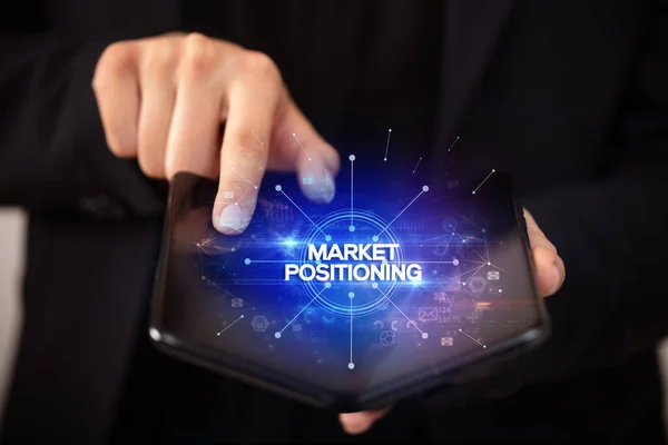 Biznesmen Składanym Smartfonem Napisem Market Positioning Nowa Koncepcja Biznesowa — Zdjęcie stockowe