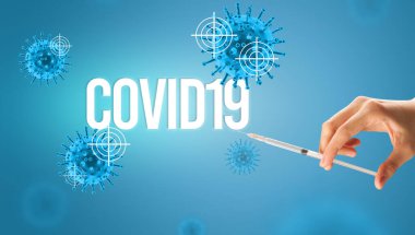 Doktorların yakından görüntüsü elinde COVID19 yazılı bir şırınga olan beyaz bir eldiven, koronavirüs panzehiri konsepti.