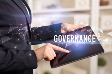 GOVERNANCE yazıtları ve modern iş teknolojisi kavramı olan tablet kullanarak elleri kapat