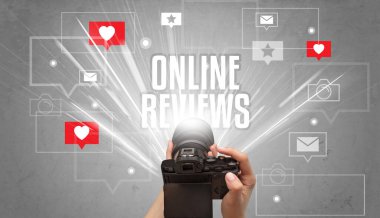 ONLINE REVIEWS yazıtları, sosyal medya kavramı ile fotoğraf çeken bir elin yakın çekimi