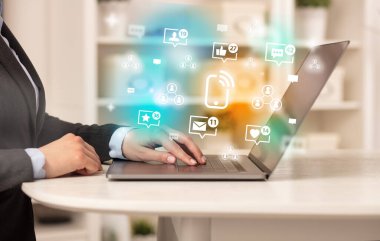Akıllı telefon simgeleriyle dizüstü bilgisayarda sörf yapan genç kişi, sosyal medya kavramı