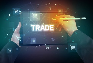 TRADE yazıtlı, çevrimiçi alışveriş konsepti olan el ele tutuşma tabletinin yakın çekimi