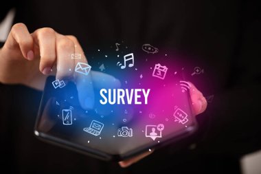İş adamı elinde katlanabilir bir akıllı telefon tutuyor. Üzerinde SURVEY yazıları, sosyal medya kavramı var.
