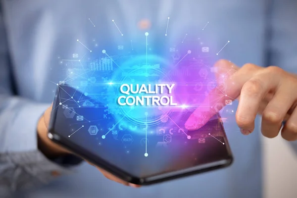 Empresário Segurando Smartphone Dobrável Com Inscrição Controle Qualidade Novo Conceito — Fotografia de Stock
