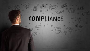 İş adamı, COMPLIANCE yazıtları ve iş stratejisi konseptiyle yaratıcı bir fikir çizimi yapıyor.